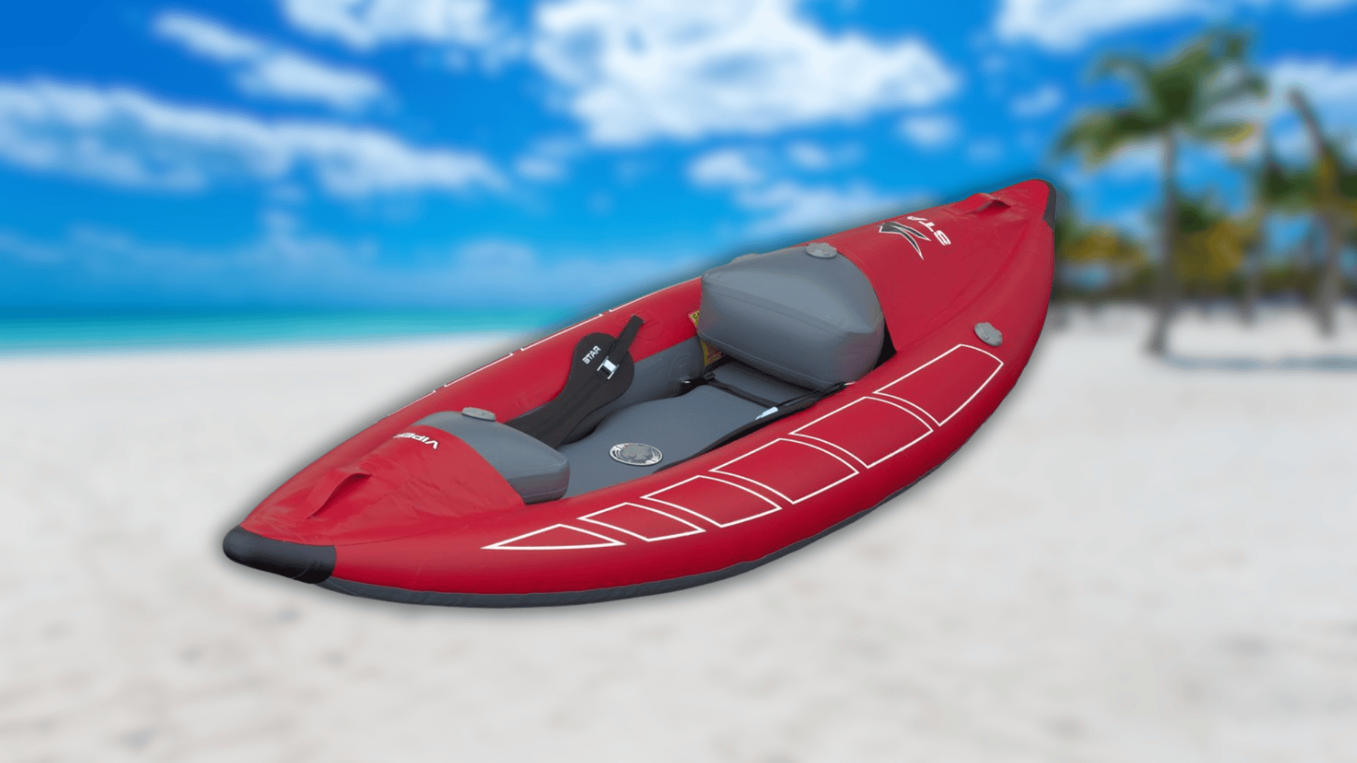 A red and grey STAR Viper inflatable kayak resting on a sandy beach.