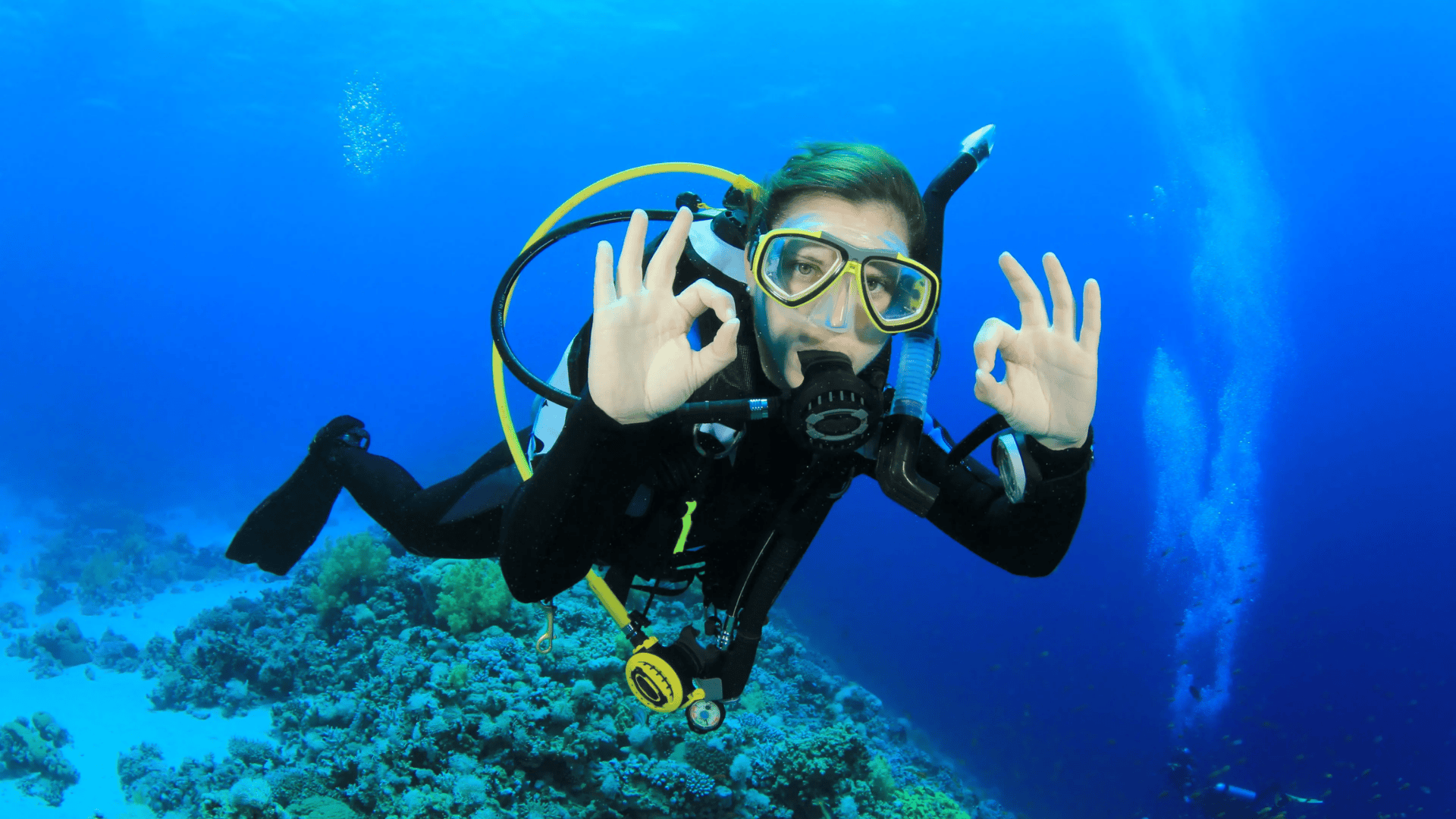a person using sign language while scuba diving