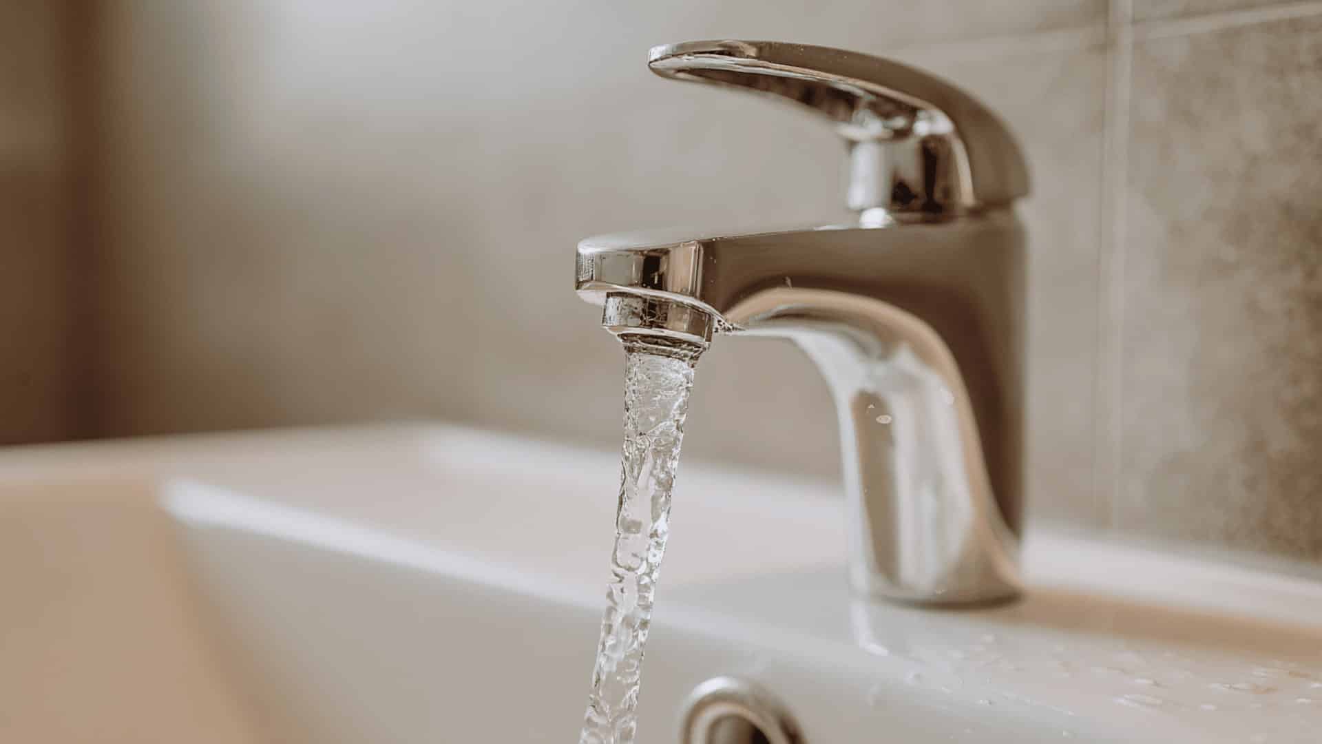 Close-up of faucet with running tap water into a sink, simple indoor white-noise sound for calm and focus