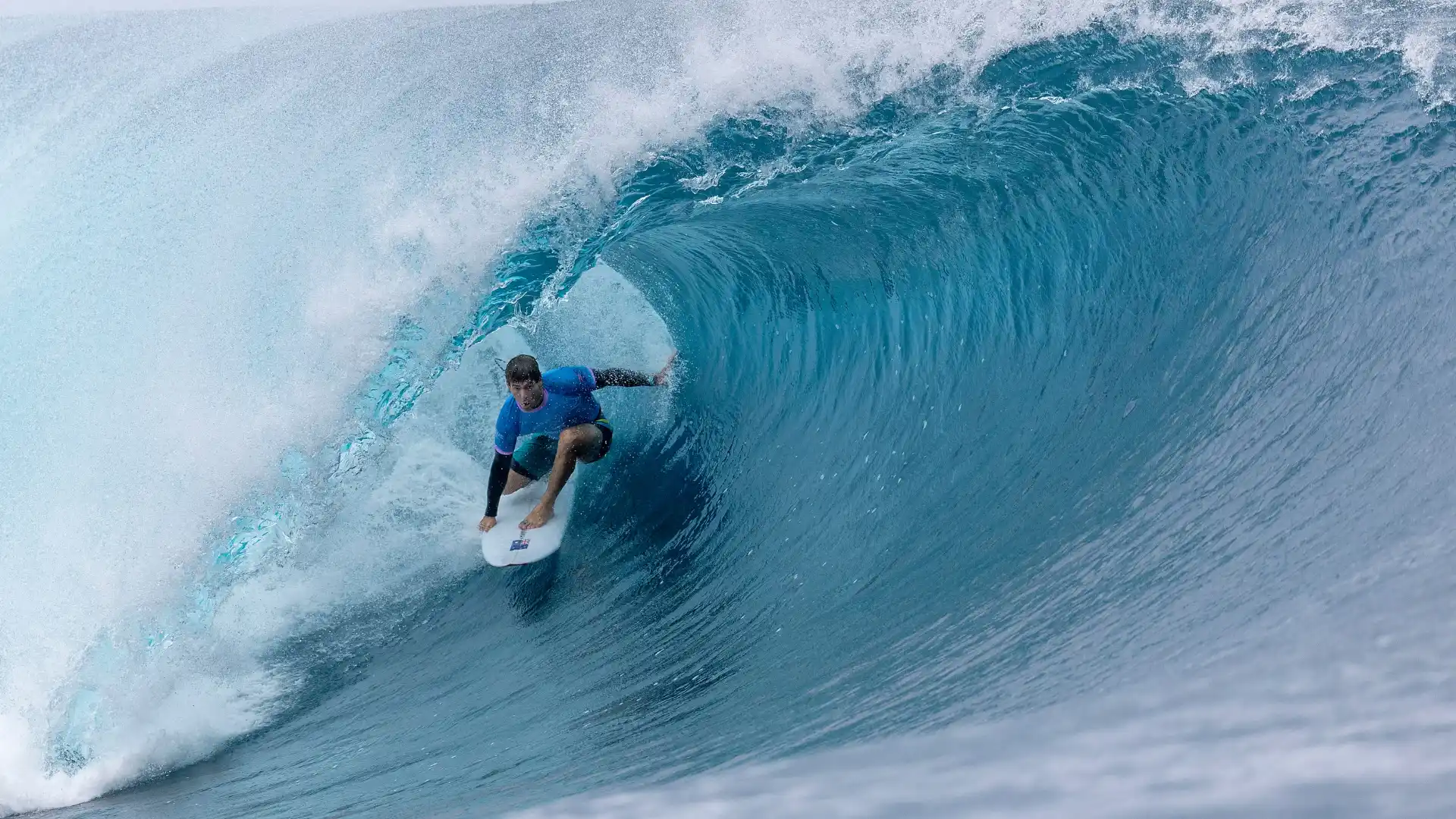 A participant surfer at the 2024 Paris Olympics, riding a wave.