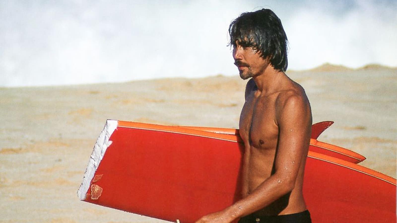 Gerry Lopez standing with surf board