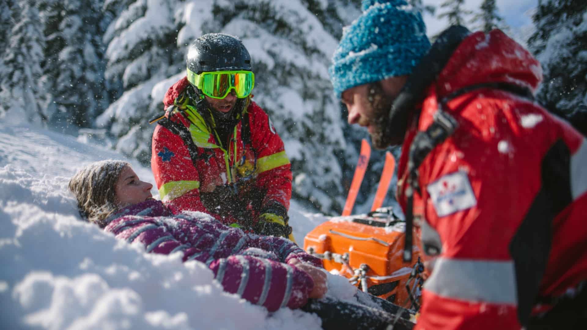 Rescuers help injured woman in deep snow during a mountain emergency call scene