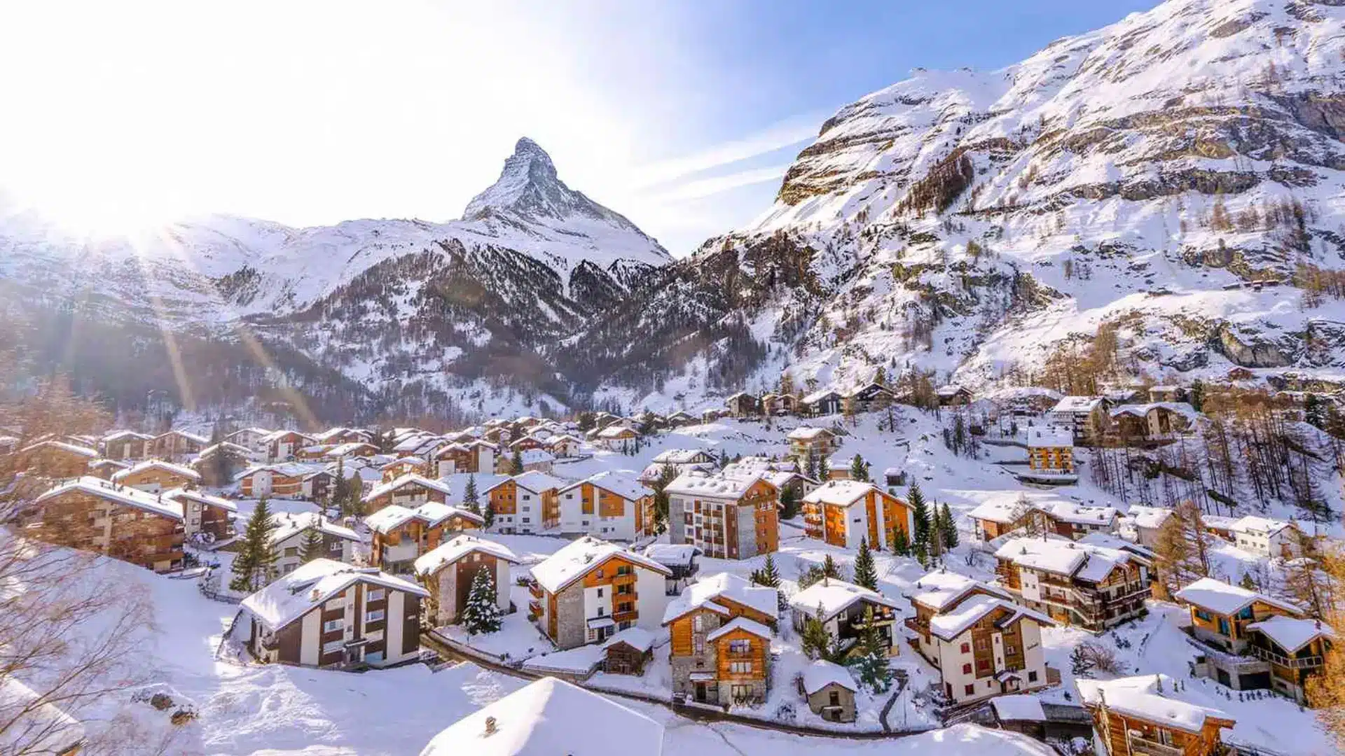 Snow-covered alpine village in Zermatt, Switzerland with traditional chalets and the Matterhorn mountain in the background
