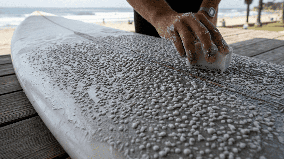 Rough, pebbly wax texture on a surfboard deck, creating a secure grip surface.
