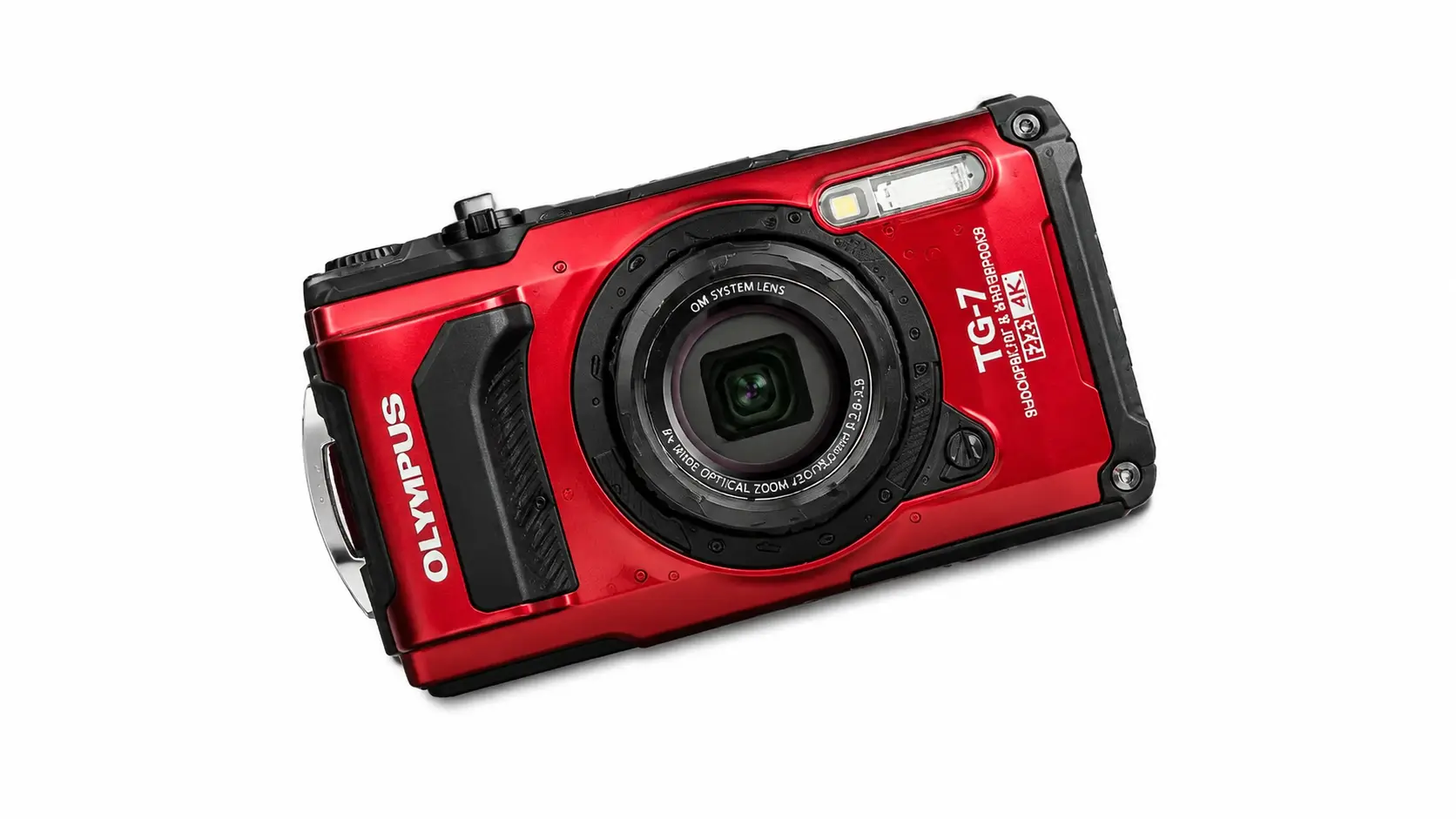 Red Olympus Tough TG-7 camera angled on a white background showing lens, textured grip, and OM SYSTEM branding