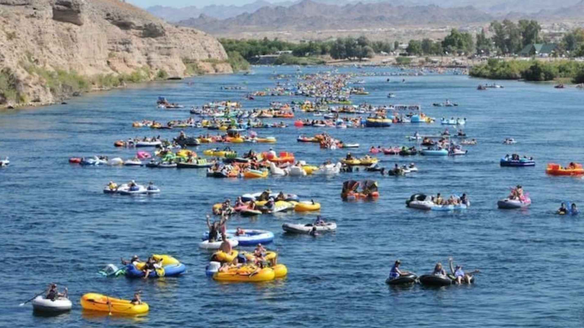 People floating in the water body surrounded by mountains