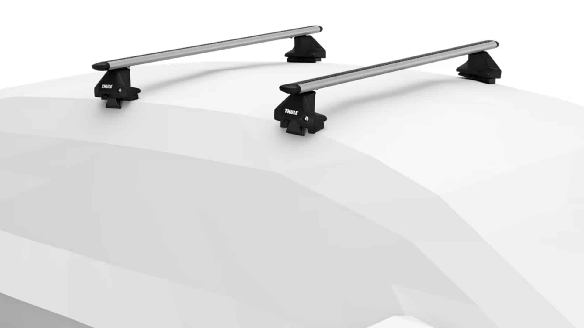 A silver Thule Evo Clamp System roof rack mounted on the roof of a white car.