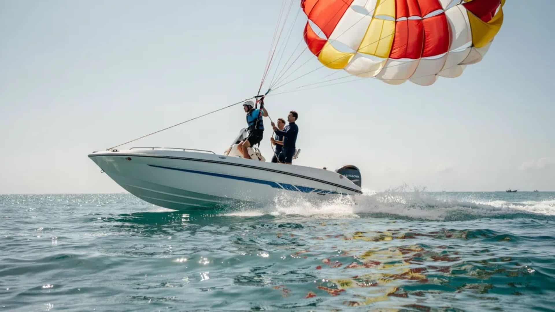 Parasailing takeoff as canopy inflates and rider lifts from speeding boat