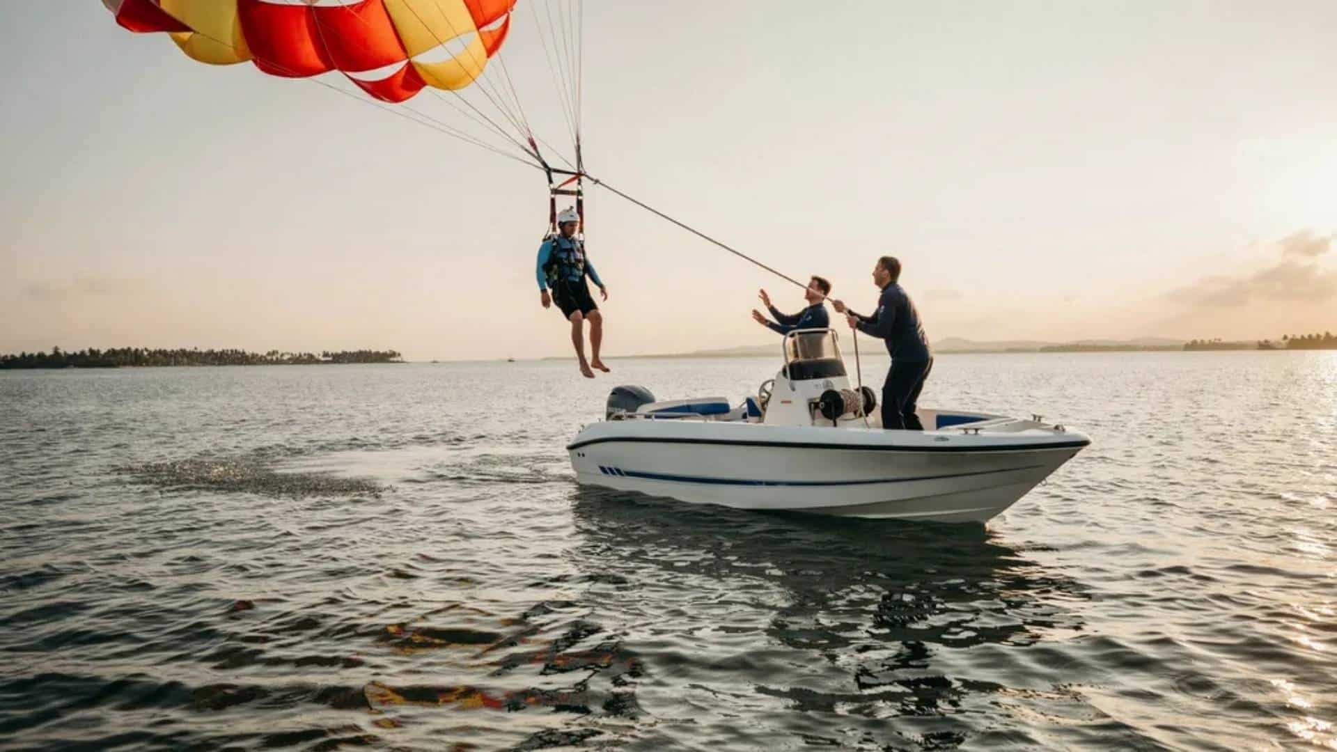 Parasailing rider lowered onto boat during controlled landing with canopy folding