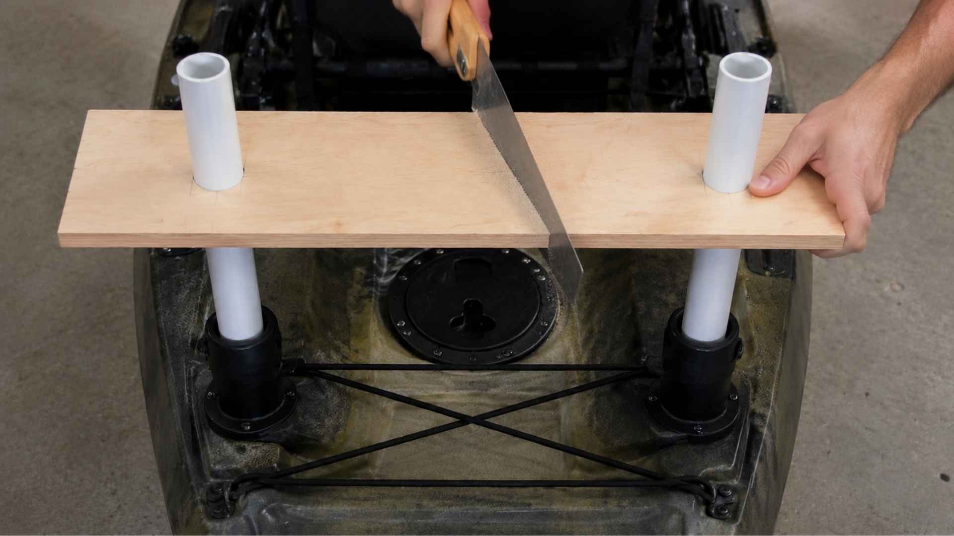 Cutting plywood board along marked line for DIY kayak motor mount build
