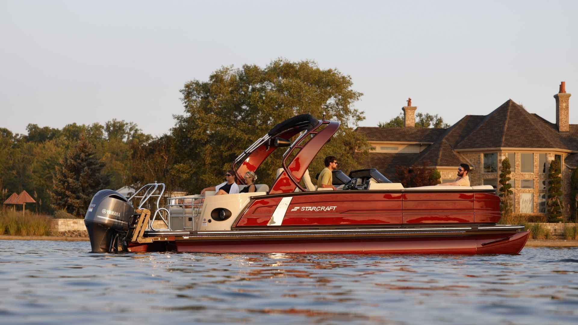 Starcraft pontoon boat docked at a quiet lake marina