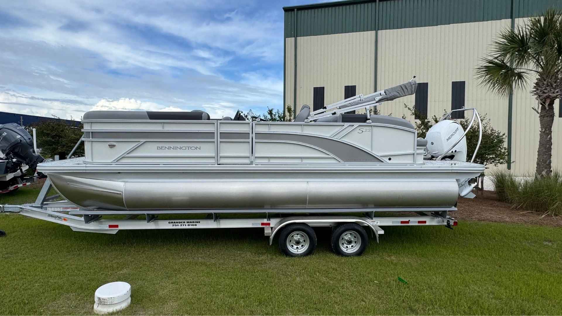 Bennington 22 SSB pontoon boat anchored on a calm lake with family