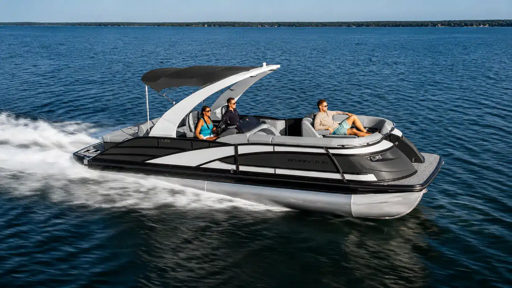 Bennington Luxury pontoon boat cruising across a blue lake