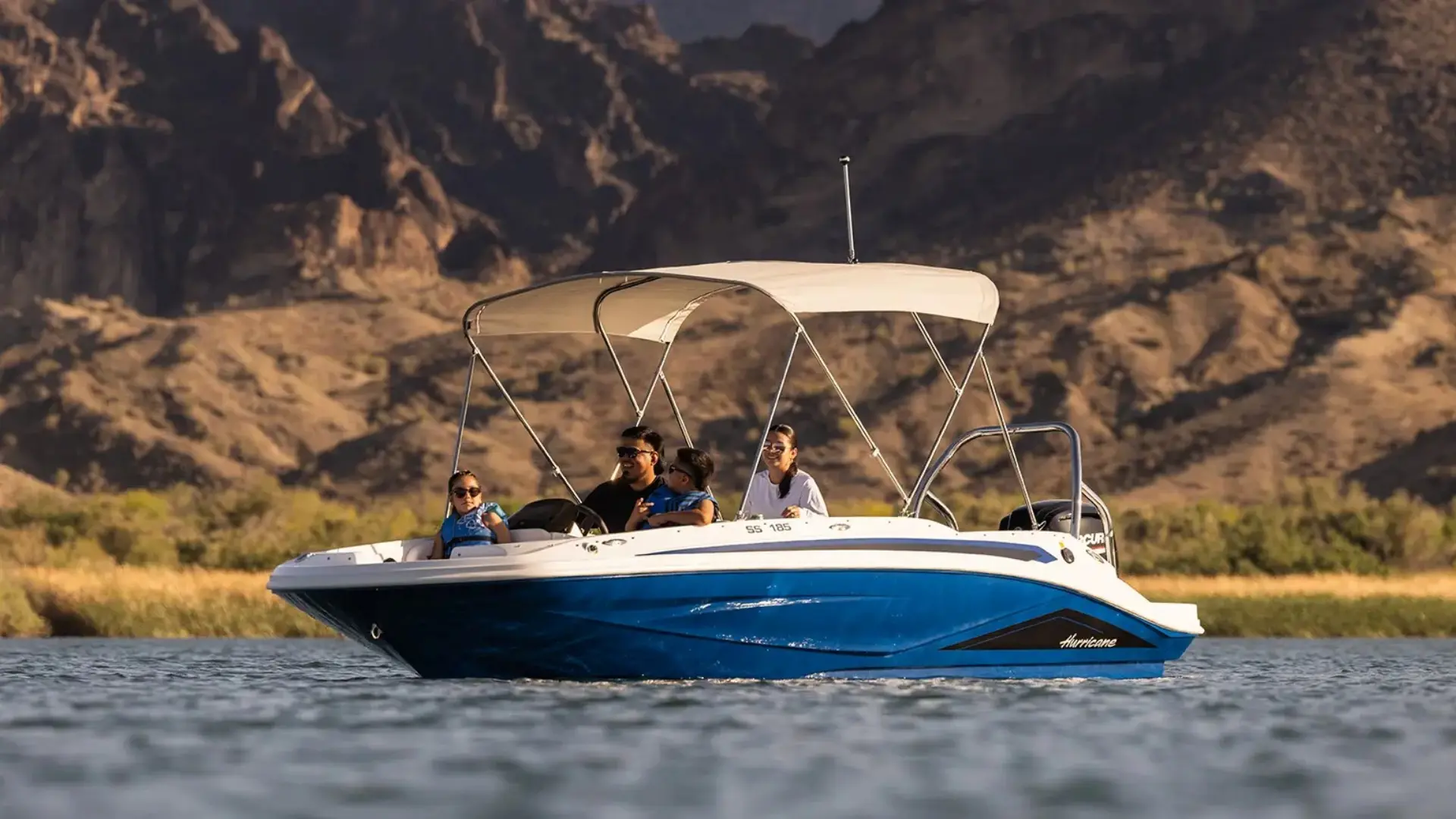 Blue Hurricane deck boat floating on lake with passengers enjoying a sunny day on the water