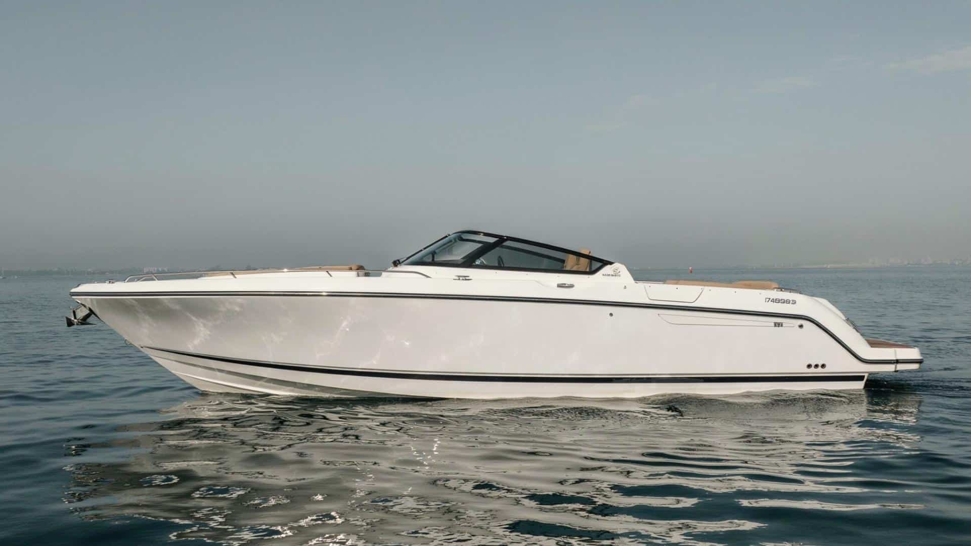 Side view of a modern recreational motorboat on calm water without labels.