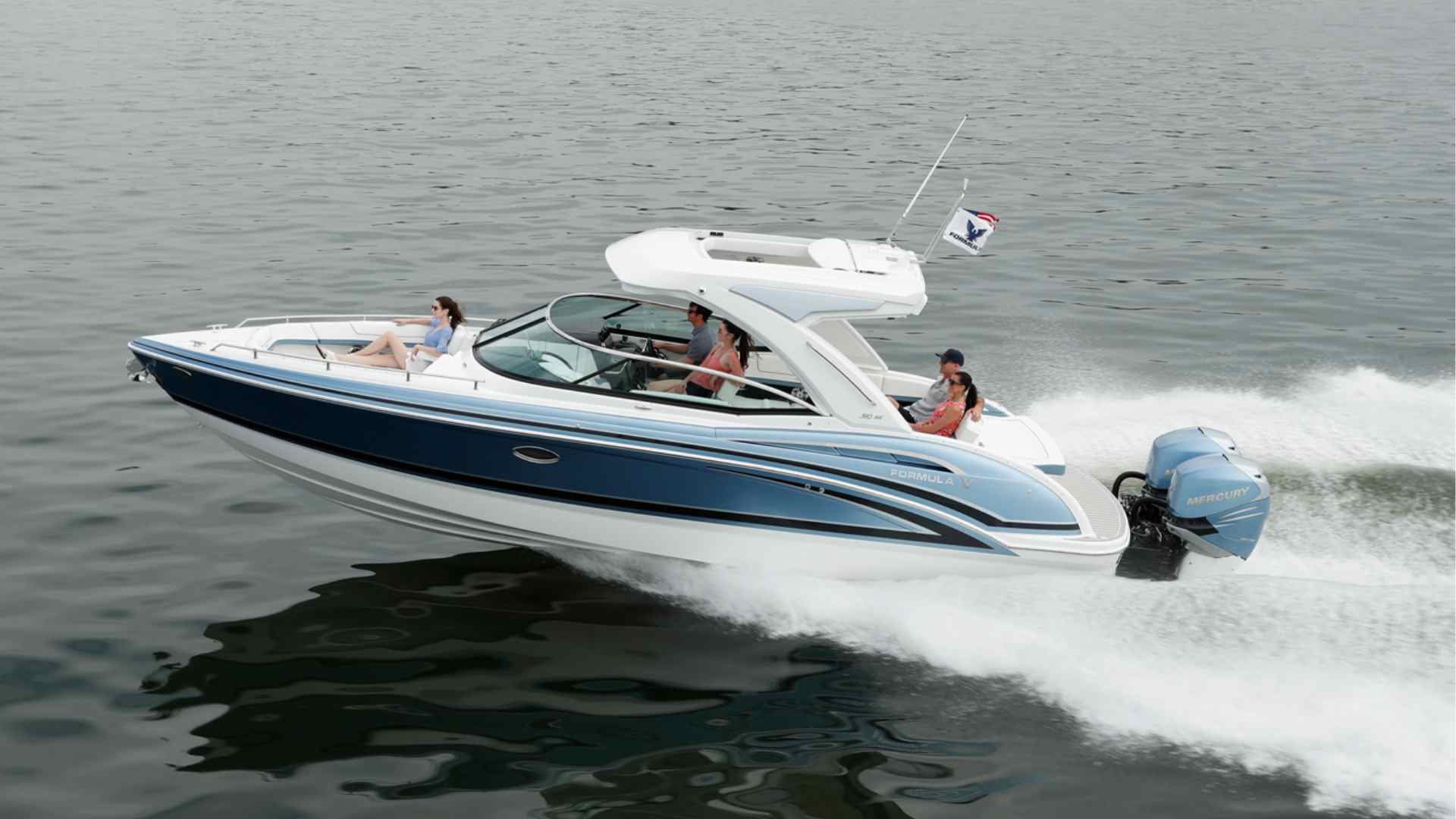 Bowrider boat carrying passengers across a scenic lake