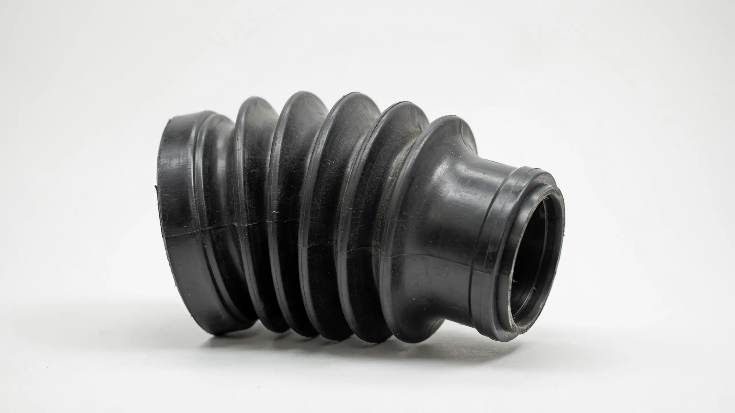 Close view of a black drive shaft bellows component with ribbed rubber design used for marine engine protection systems