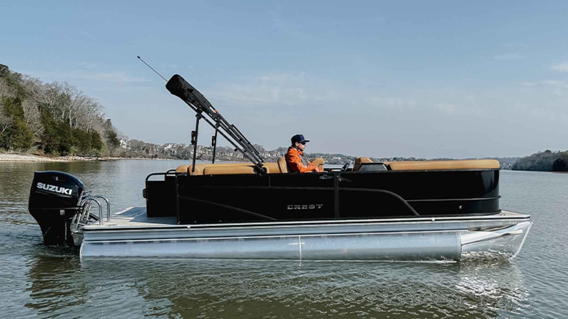 Crest pontoon boat with modern styling cruising on a lake