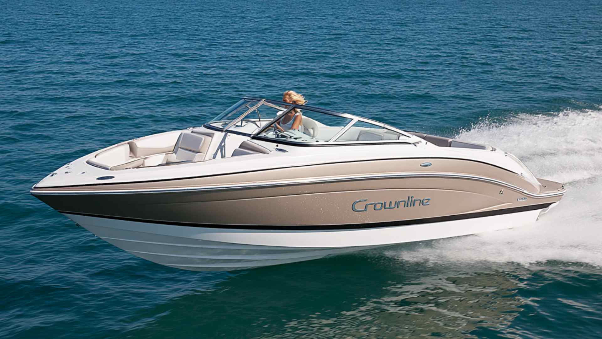 Deck boat cruising across a lake with an open seating area