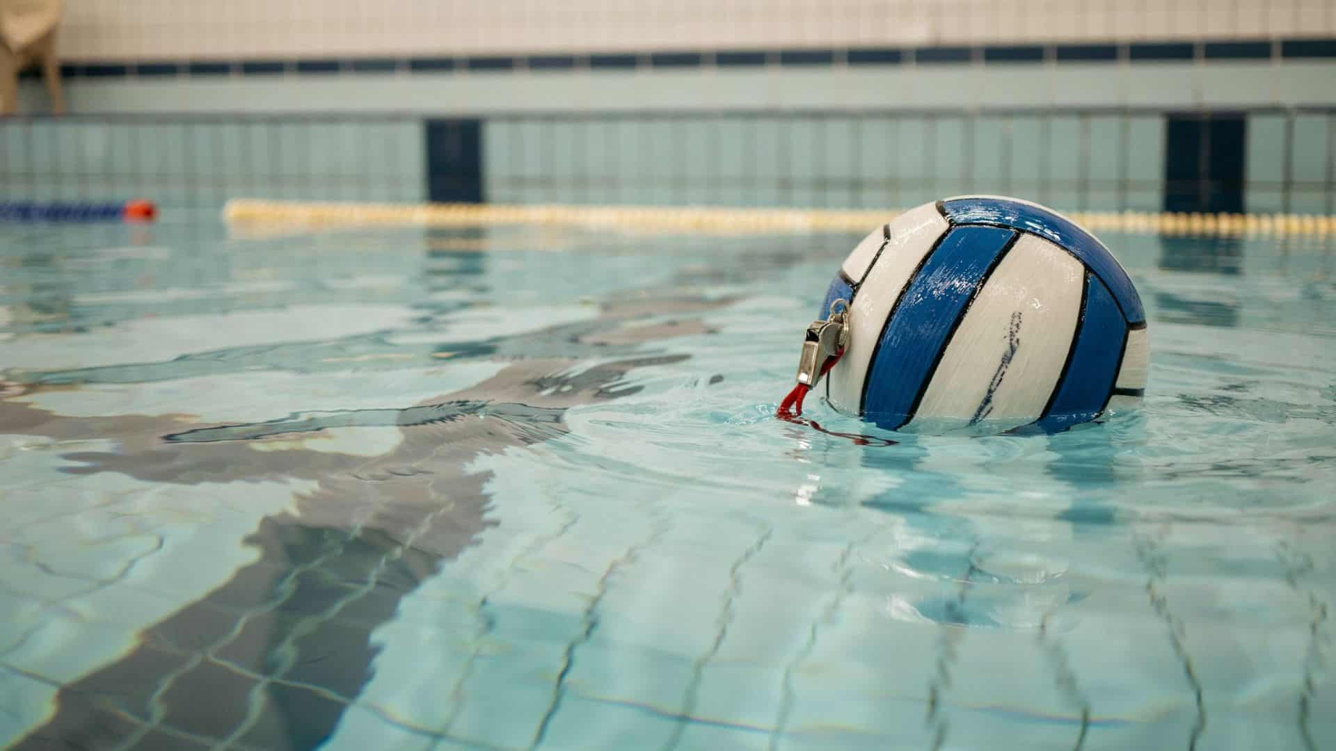 Close-up view of a water polo ball floating in a pool representing minor fouls and game rule violations in water polo