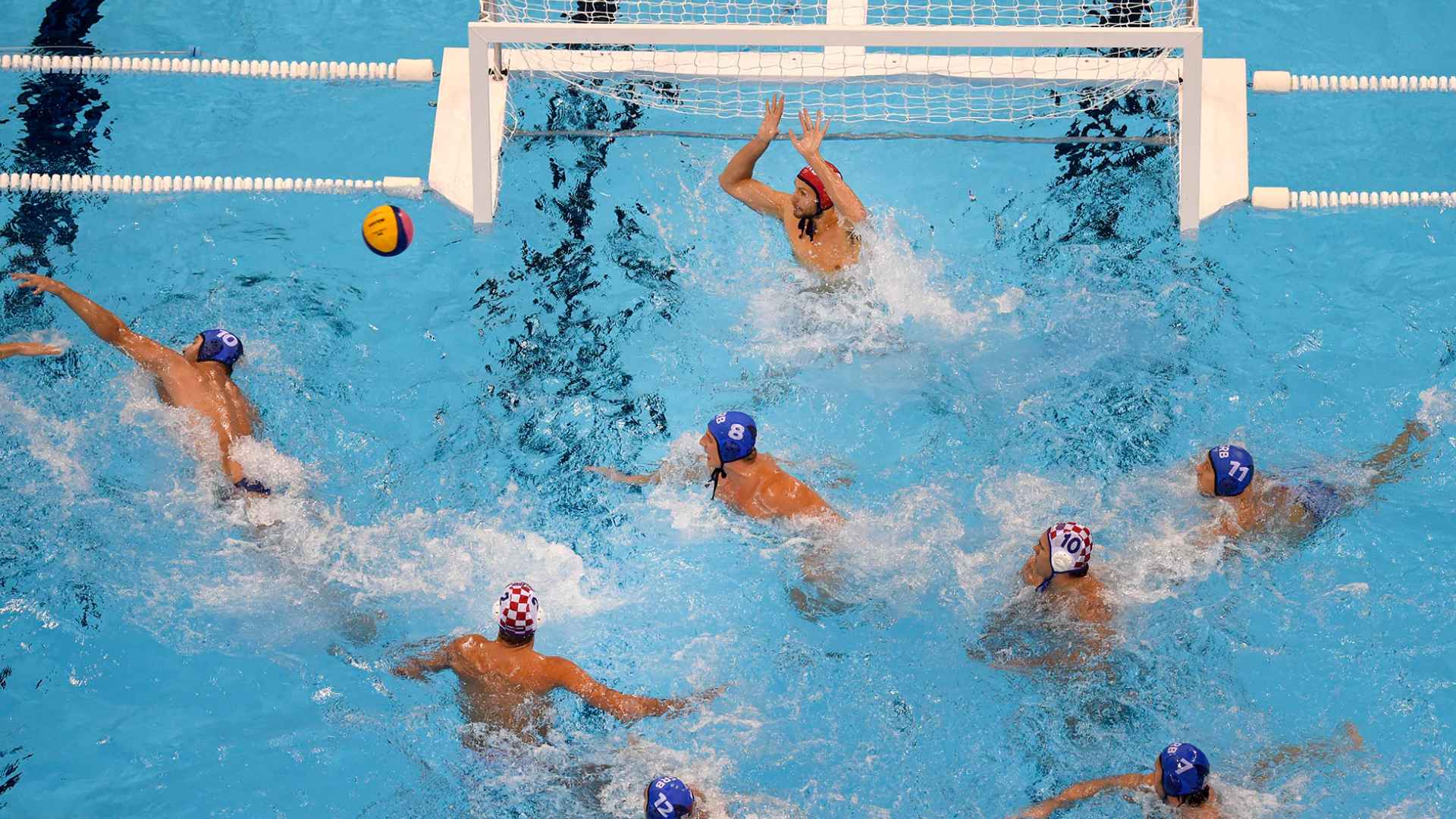 Realistic water polo formation in a swimming pool with labeled positions including goalkeeper, point, wings and drivers