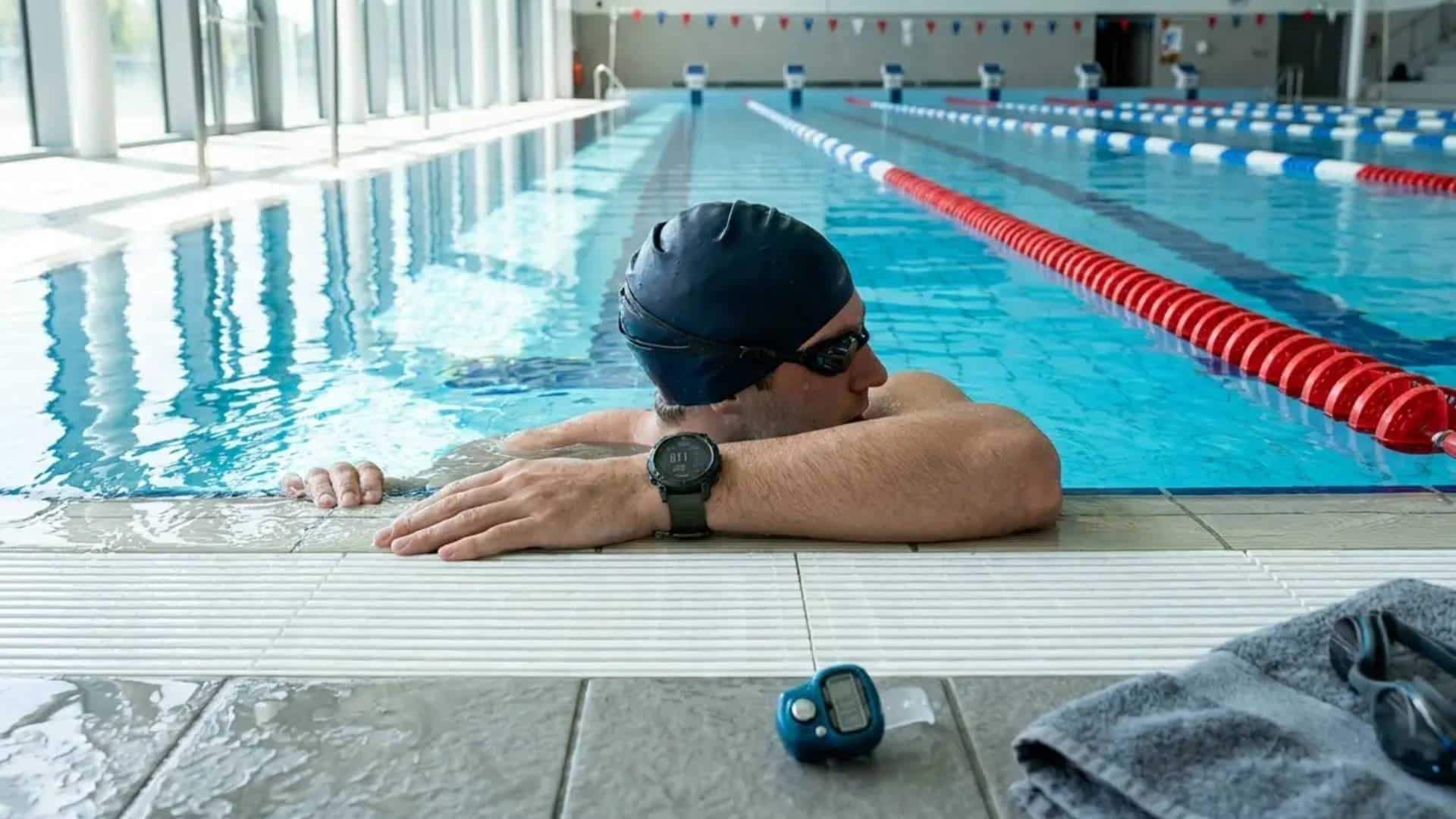 Swimmer tracking completed laps with a waterproof fitness watch.