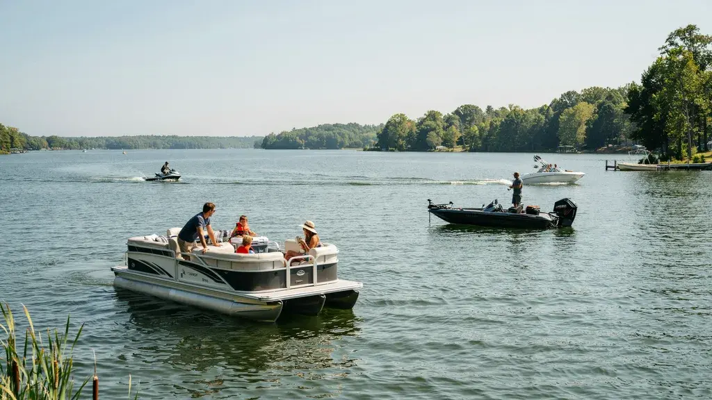 Types of boats for lakes showing pontoon, fishing boat, and watercraft enjoying a scenic freshwater lake outing