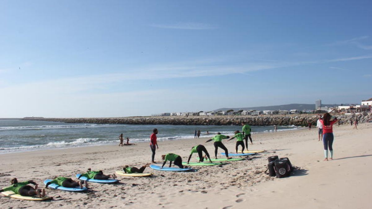 Surf lesson on a sandy beach in Figueira da Foz, Portugal with beginners practicing near Atlantic waves