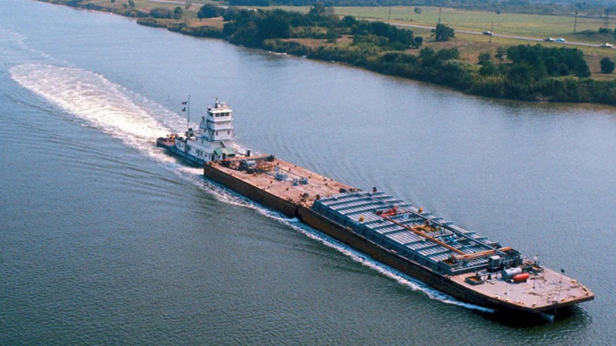Commercial barge carrying freight along the Intracoastal Waterway on a modern inland shipping route.